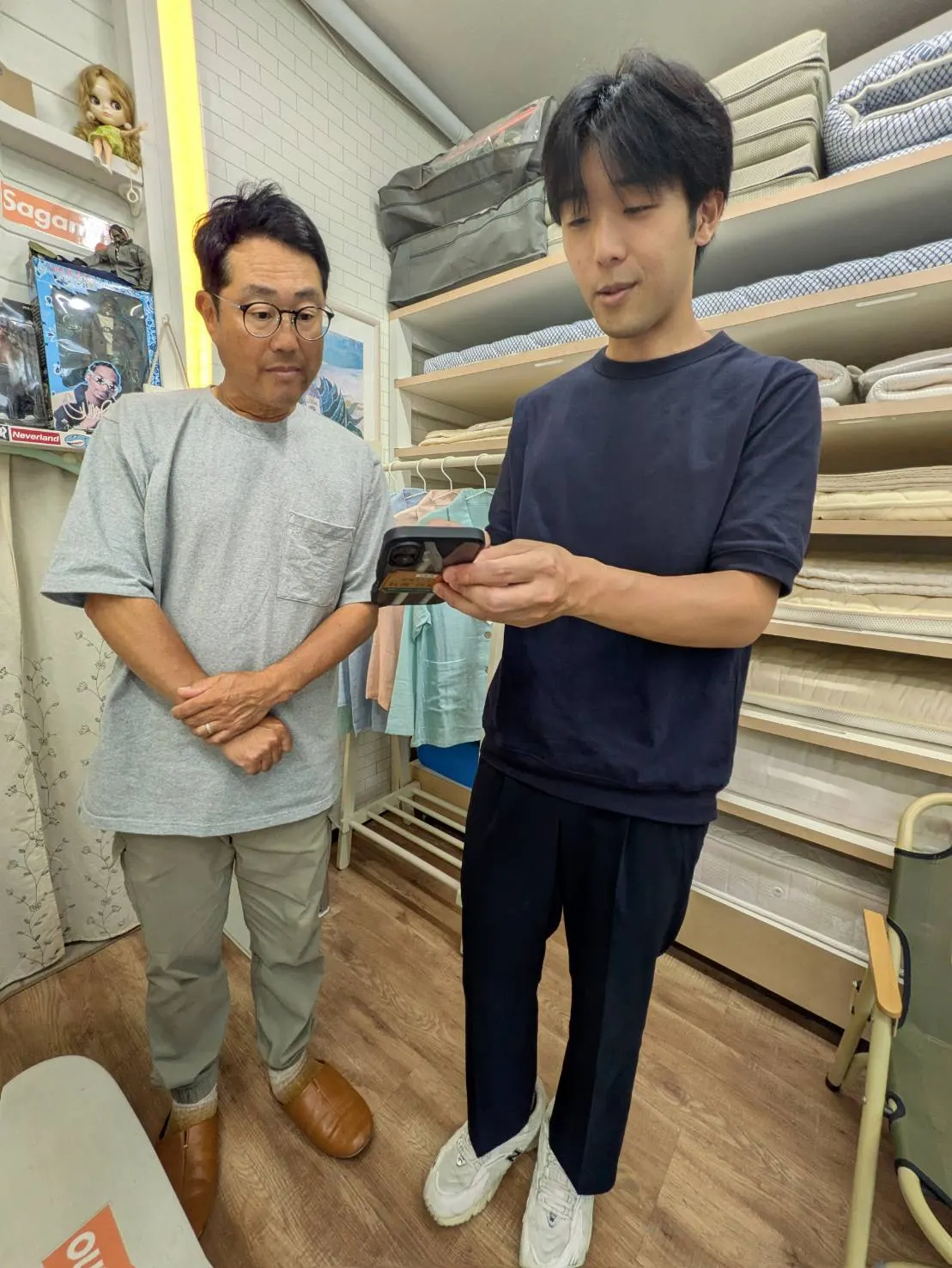 街の布団屋さん さがみ野（マニフレックス相模原）様とS-passo担当者が店内でスマートフォンの画面を確認している様子